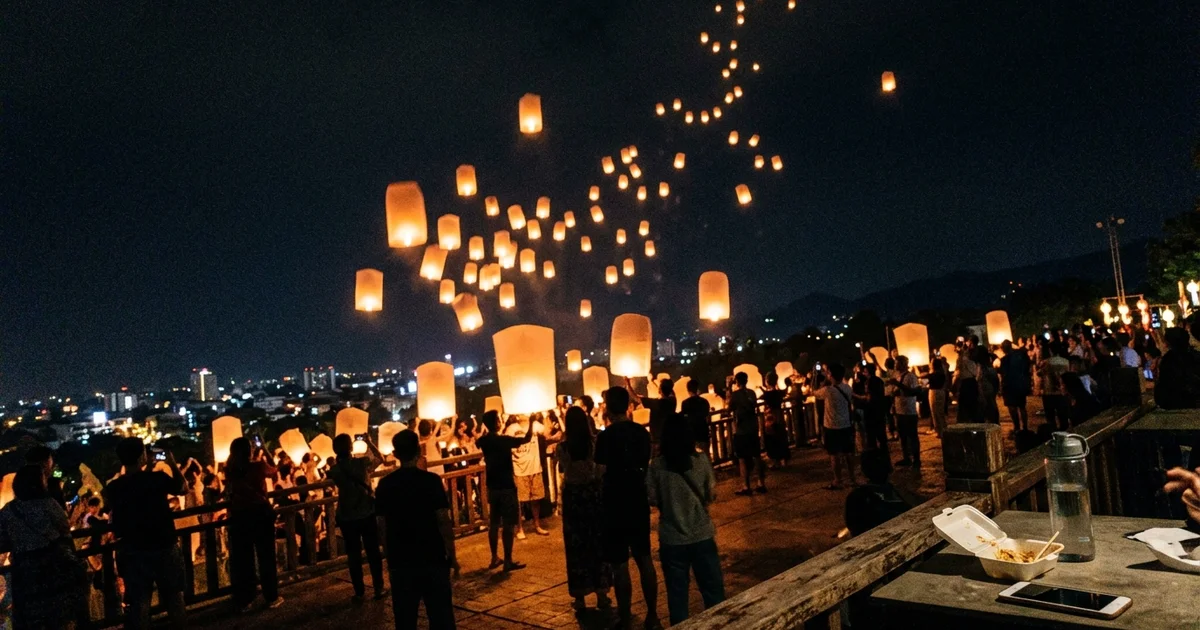 Sky lanterns rising over Chiang Mai at night during Yi Peng
